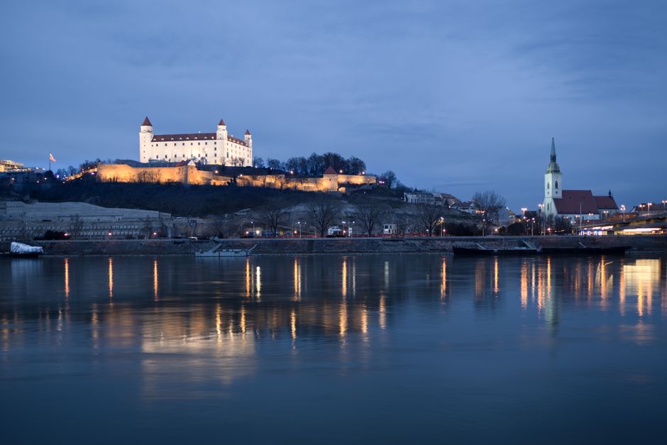 A captivating nighttime view of Bratislava Castle reflected in the Danube River