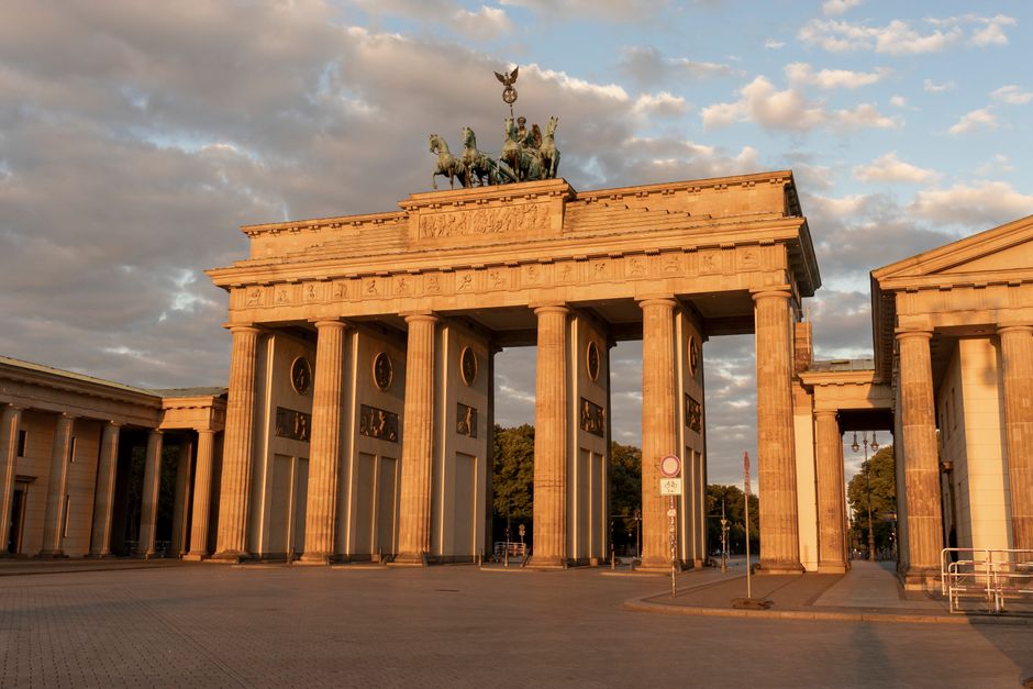 A classic view of the Brandenburg Gate in Berlin, showcasing neoclassical architecture beneath a cloudy sky