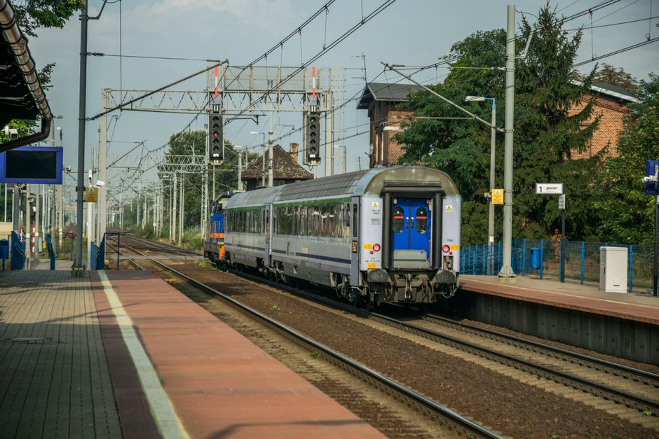 A passenger train departing from a railway station in Wrocław, Poland, showcasing urban transportation
