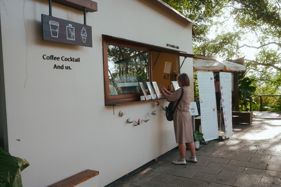 A person ordering coffee at an outdoor coffee stand with menus and decorations