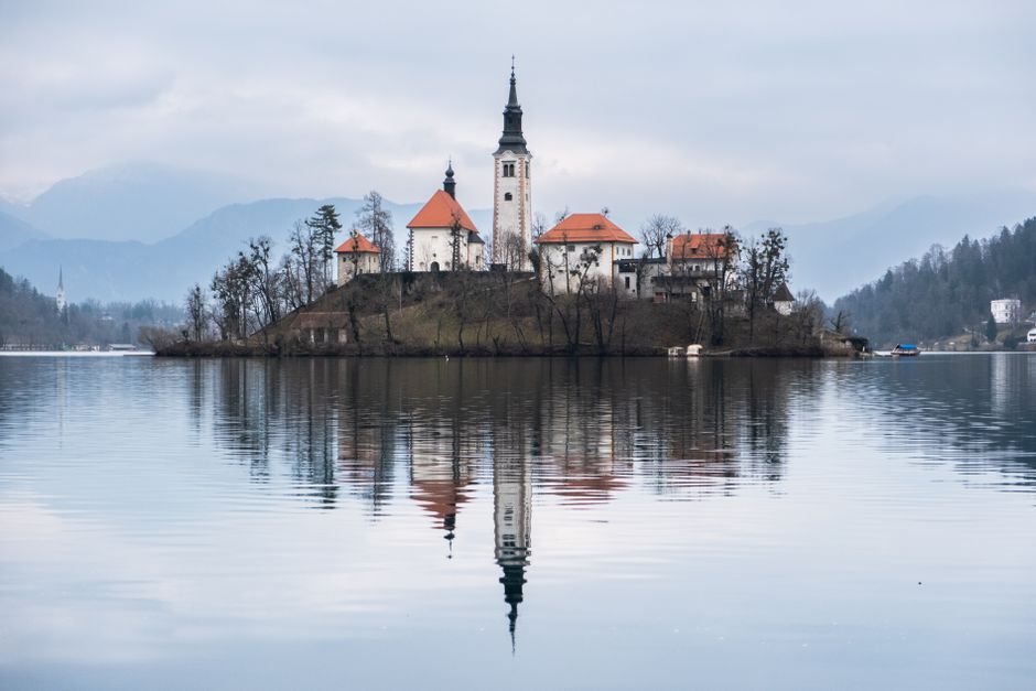 A serene view of Bled Island with church reflecting on Lake Bled in Slovenia