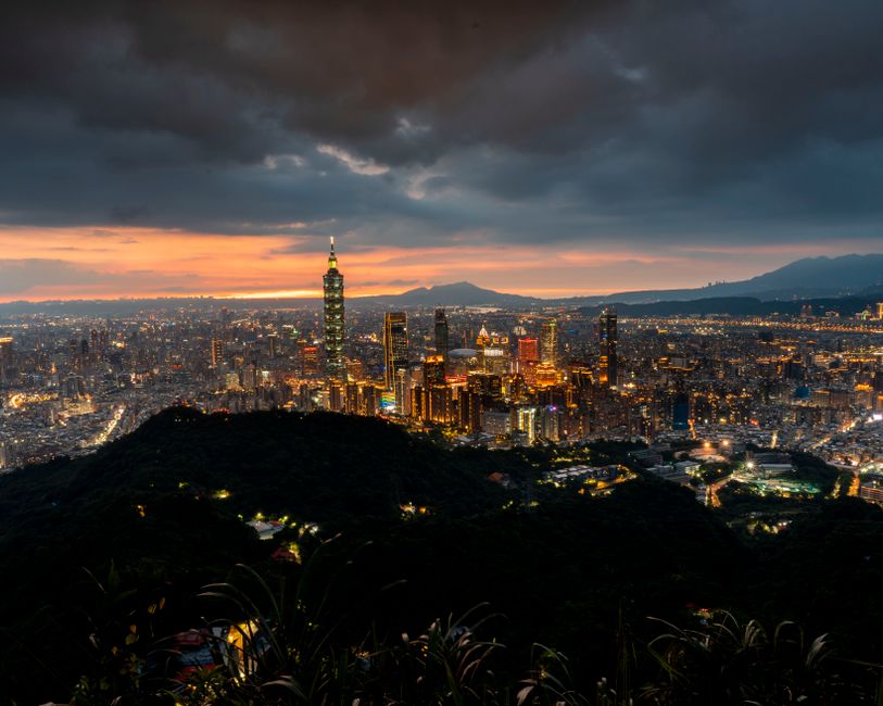 A stunning aerial view of Taipei cityscape with a dramatic sunset sky