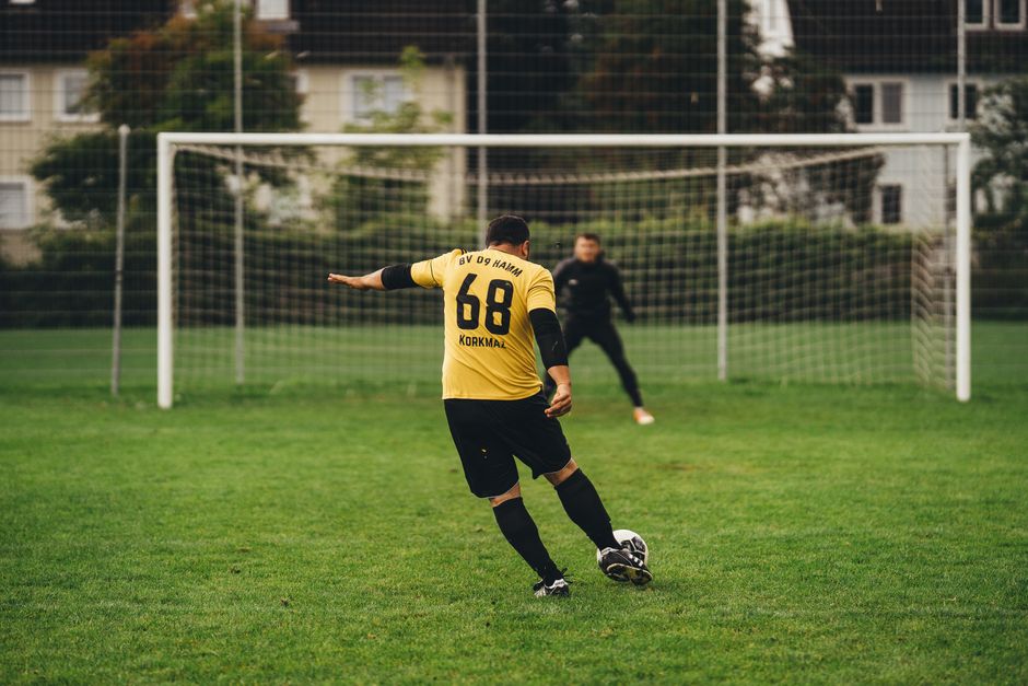 A player aims to score a goal during a soccer game on a lush green field.