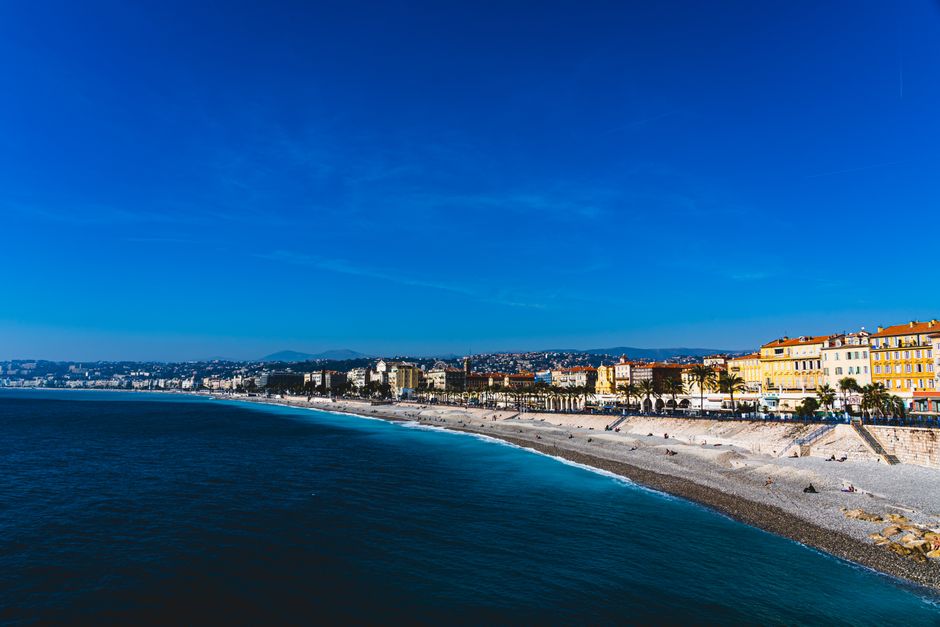 A vibrant beachfront view of Nice, France, capturing the azure waters and colorful architecture on a sunny day.
