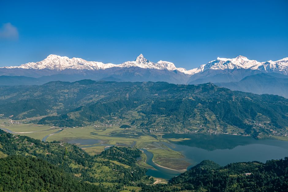 Breathtaking view of Annapurna range and Phewa Lake in Nepal under clear blue skies