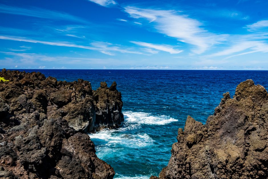Breathtaking view of rugged rocks and vibrant blue ocean at Hana, Hawaii under a clear sky