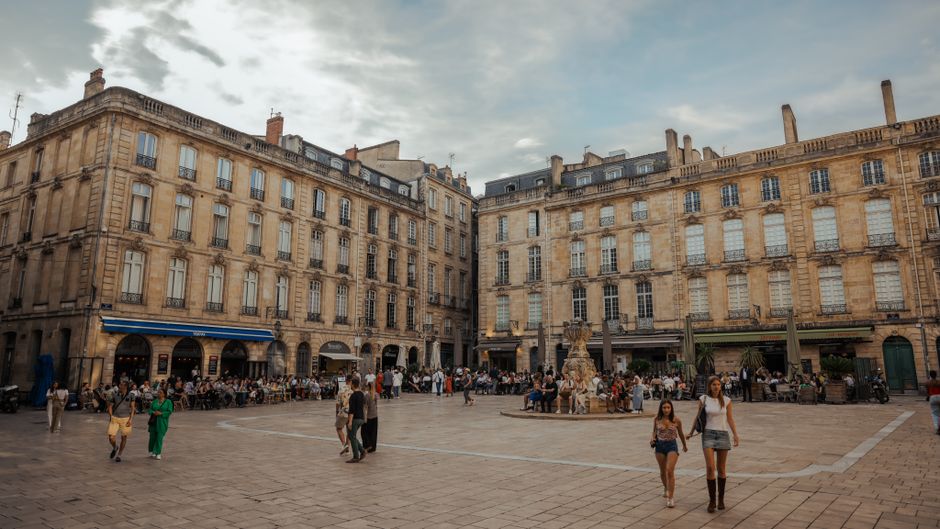 Bustling city square in Bordeaux, France with people enjoying summer activities