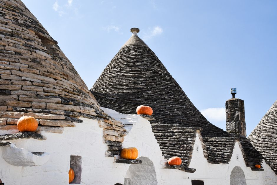 Charming trulli houses with pumpkins on roof in sunny Apulia