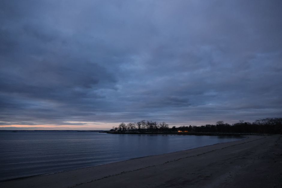 Serene beachscape with overcast sky at twilight, capturing the peaceful and moody atmosphere.