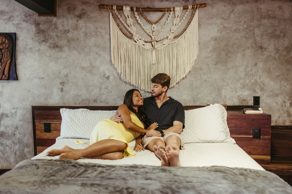 A couple relaxing on a bed with macrame decor, capturing a warm and intimate moment.