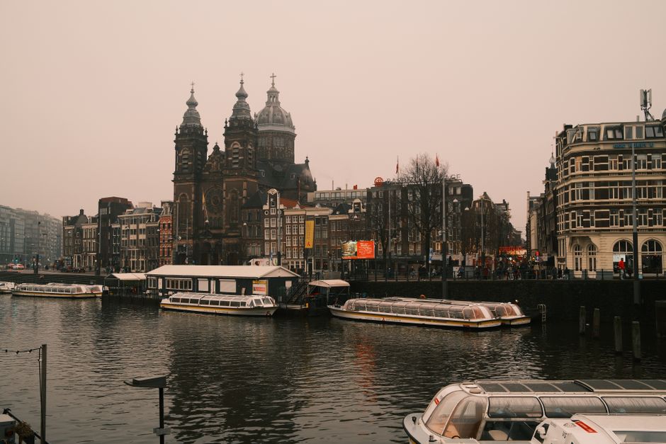 Beautiful capture of Amsterdam's canals and classic architecture during a foggy day.