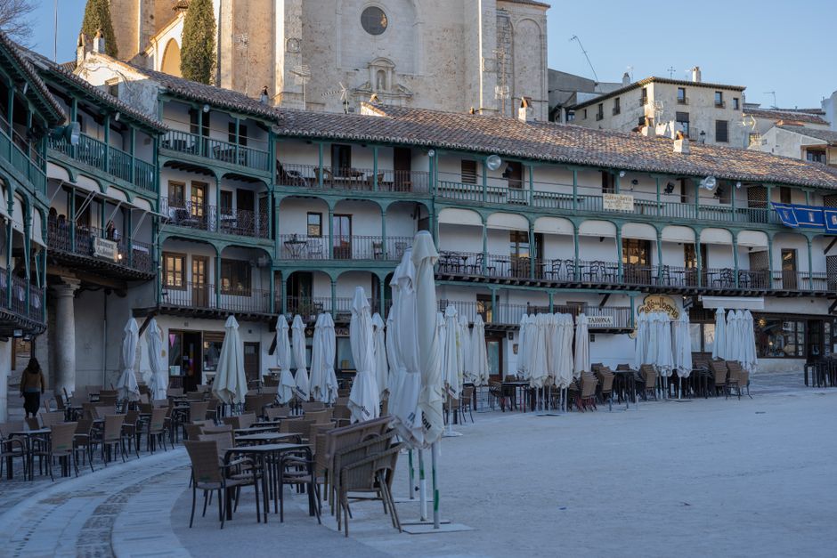 Empty café tables in a historic plaza in Chinchón, Madrid, Spain