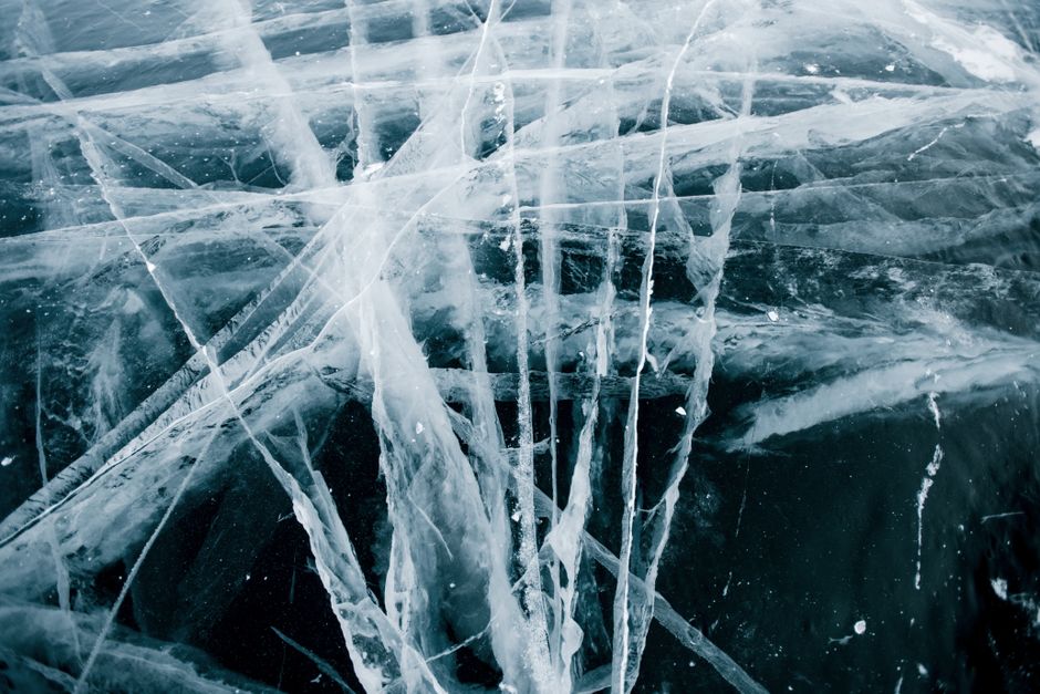 Stunning close-up of intricate cracked ice patterns on a Russian lake, showcasing nature's icy art.