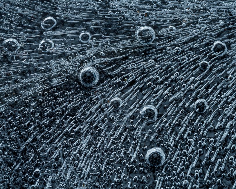 Macro shot of black feather of bird with air texture and short strokes and circles of different types