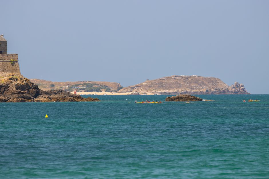 Vibrant summer view of Fort National and kayakers in Saint-Malo, Brittany, France.