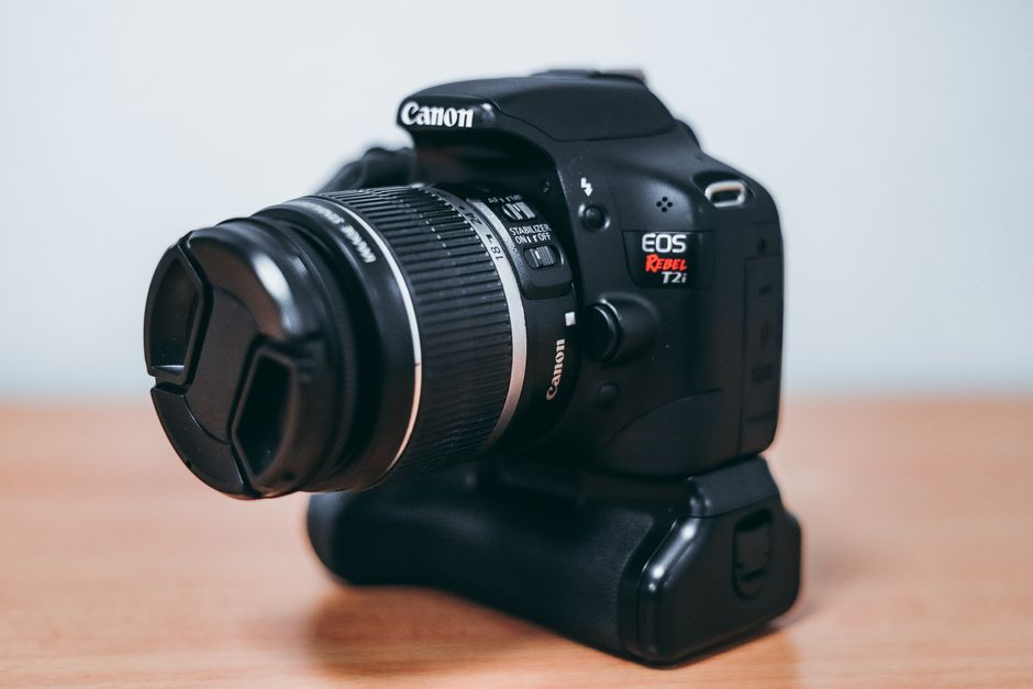 High-resolution image of a digital camera and lens on a wooden surface.