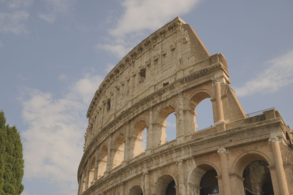 Low-angle view of the iconic Colosseum in Rome with a clear blue sky.