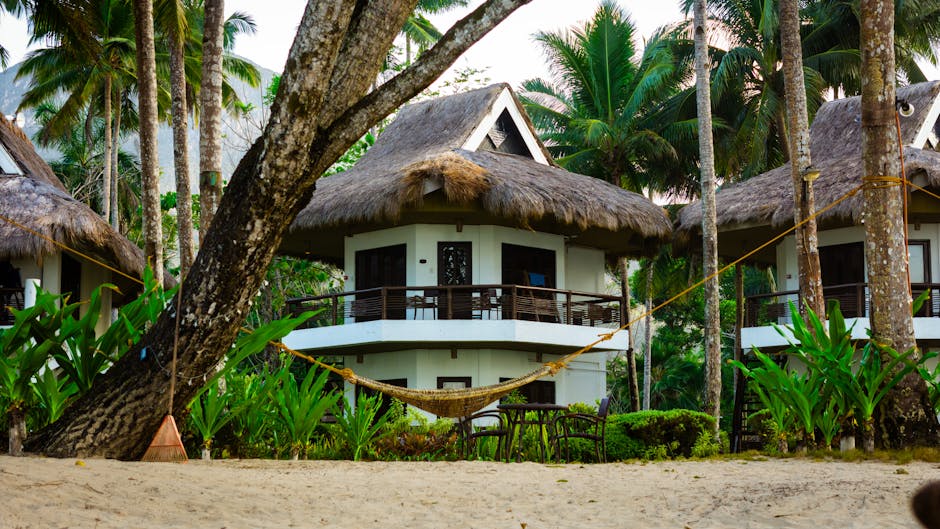 Cozy beachfront cottages amidst lush palm trees in Palawan, perfect for a tropical getaway.