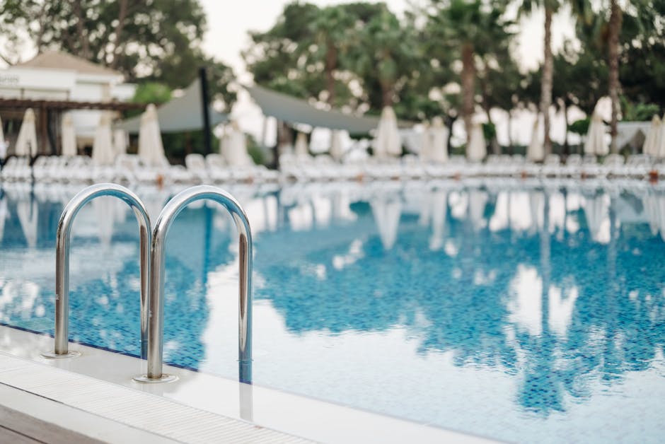 A peaceful poolside scene featuring a stainless steel ladder and relaxing ambiance.