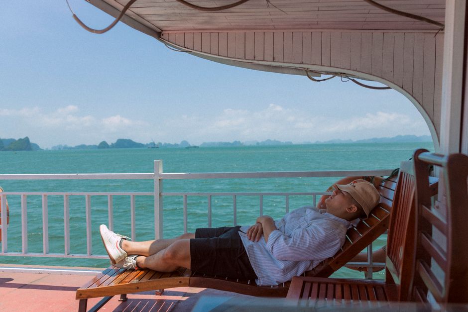Man lounging on a boat, enjoying a peaceful sea view under a clear sky