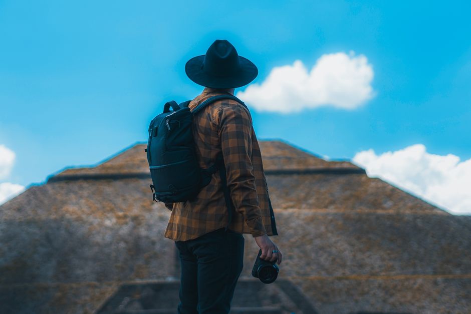 Man with a backpack and camera exploring the pyramids of Teotihuacan, Mexico