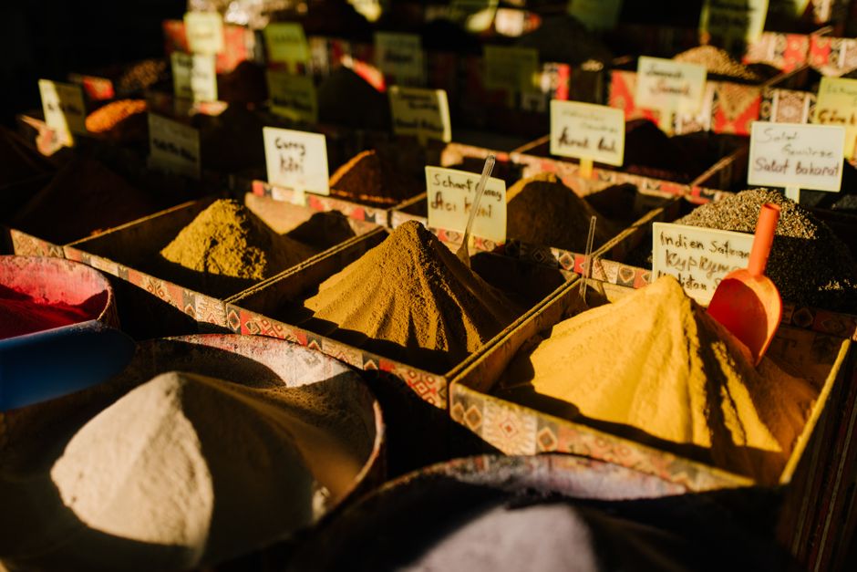 Assorted oriental spices in boxes placed on table in outdoor local bazaar on sunny day