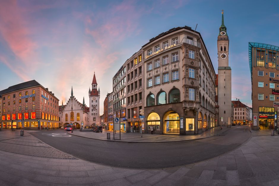Panoramic view of Marienplatz in Munich, Germany, showcasing historic buildings and a clock tower at dusk