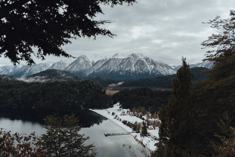 Scenic winter landscape in Neuquén, Argentina, featuring snow-covered mountains and a tranquil lake.