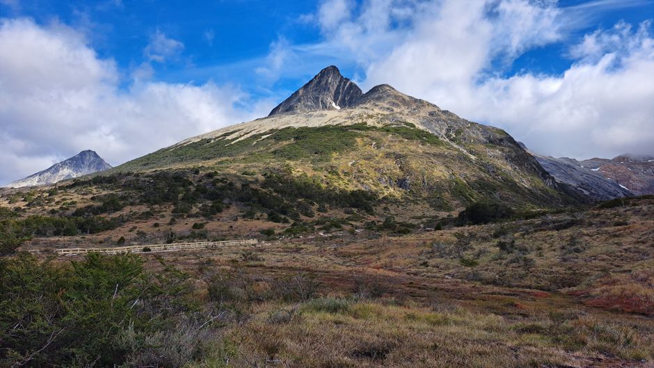 Scenic landscape of mountainous terrain under a blue sky in Tierra del Fuego, Argentina.