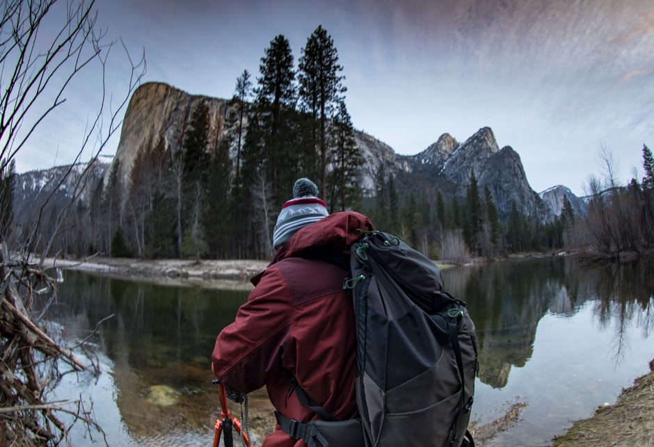 Hiker photographs scenic view of Yosemite's El Capitan during winter adventure.