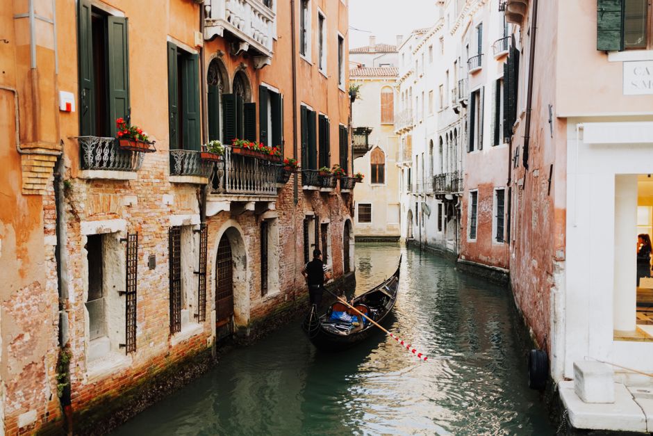 Picturesque view of a gondola on a narrow canal in Venice, Italy, surrounded by charming buildings