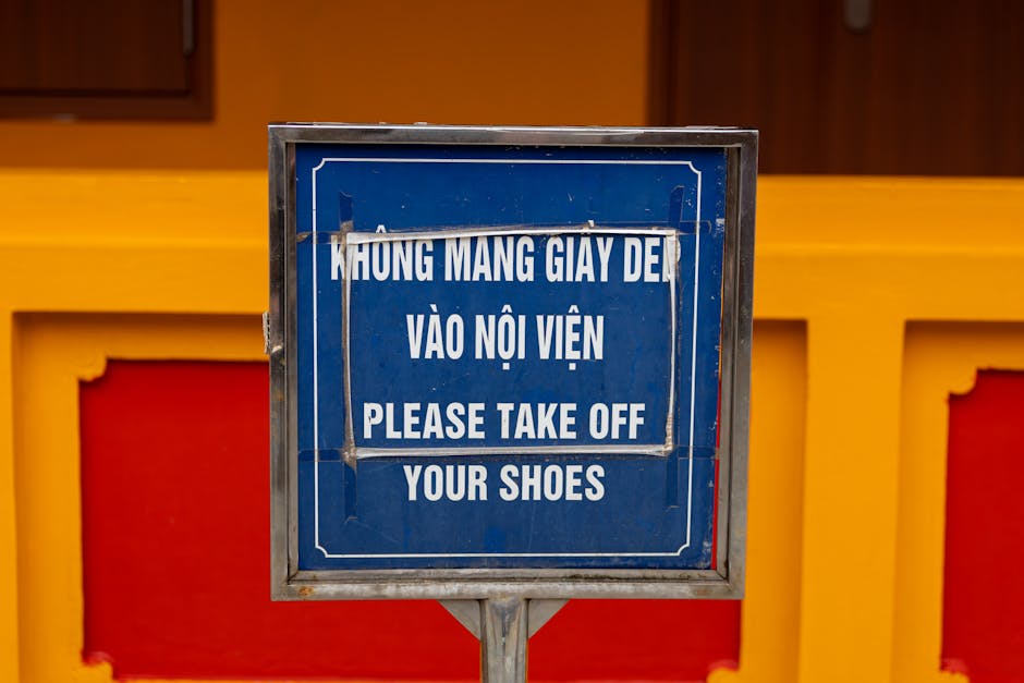 Close-up of bilingual sign in Hà Nội, Việt Nam, advising to remove shoes before entering.