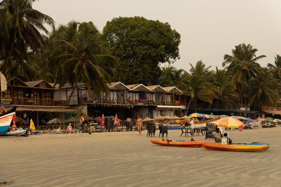 Relaxing beachfront with colorful kayaks, palm trees, and vibrant outdoor seating in tropical setting