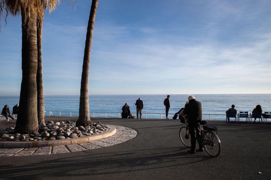 Relaxing day on Nice's famous Promenade des Anglais, with people enjoying the scenic view and coastal breeze