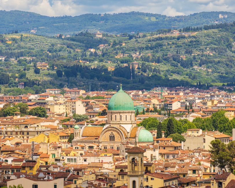 Aerial view of Florence, Italy showcasing the iconic Great Synagogue with lush hills in the background.
