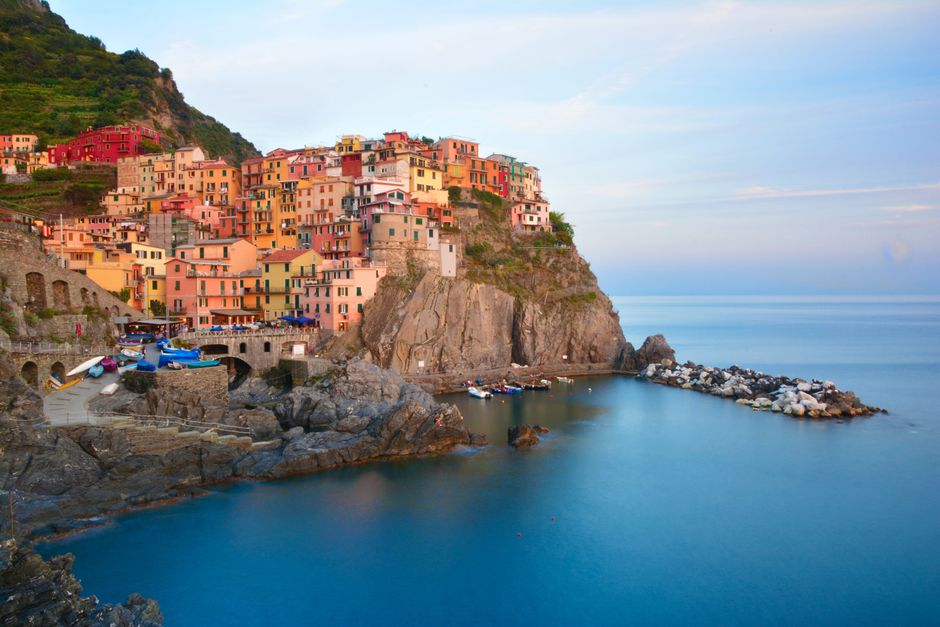 Scenic view of colorful houses and cliffs in Manarola, Liguria, Italy during summer
