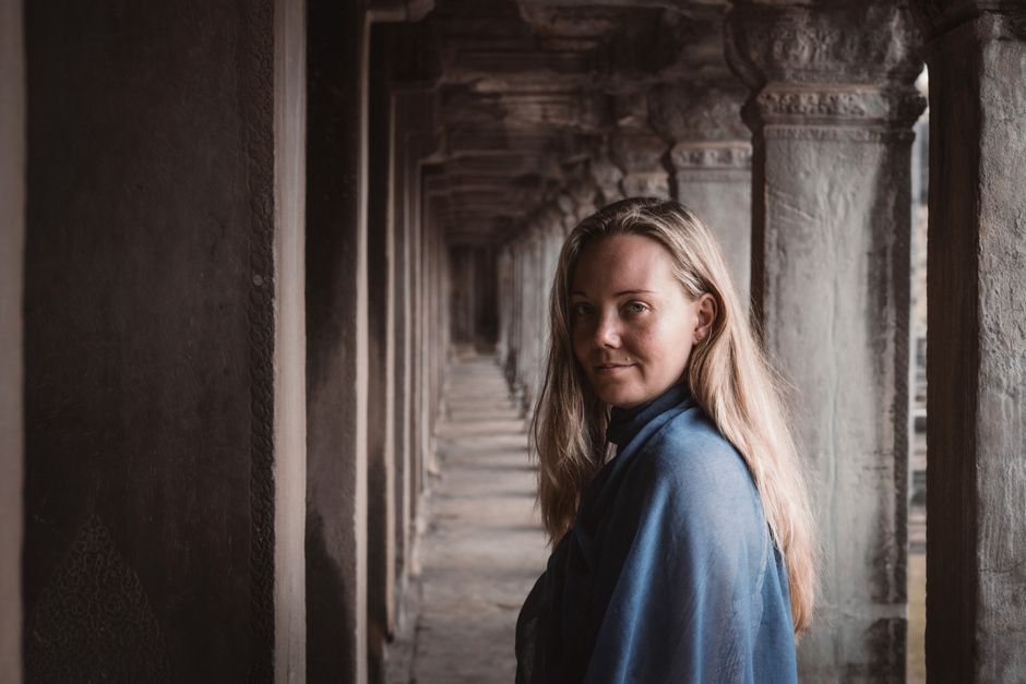A peaceful portrait of a woman in the iconic Angkor Wat temple corridor, capturing the timeless beauty of Cambodia.