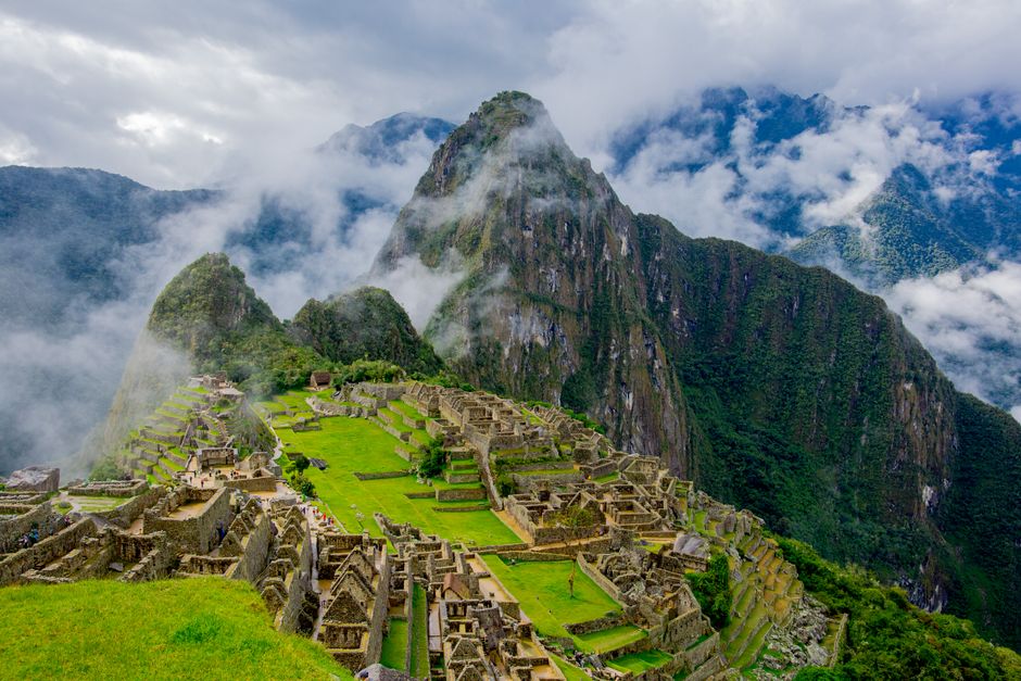 Stunning aerial view of Machu Picchu ruins surrounded by lush mountains and mist
