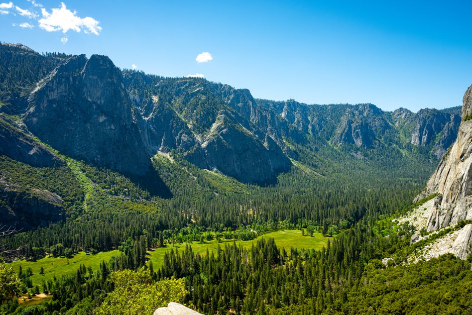Stunning aerial view of Yosemite Valley with lush greenery and towering mountains under a clear blue sky