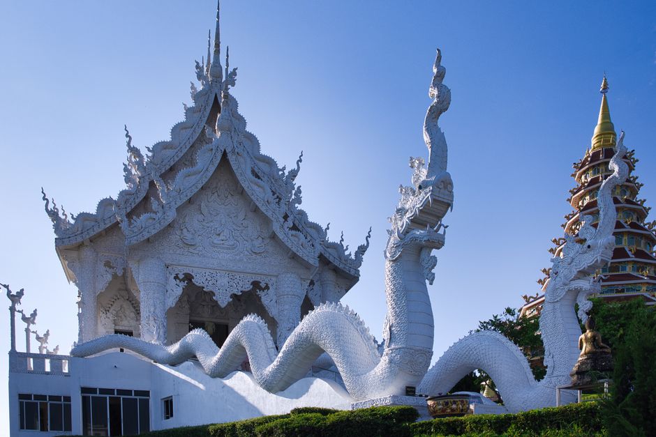 Stunning ornate white temple with dragon sculptures in Chiang Rai, Thailand