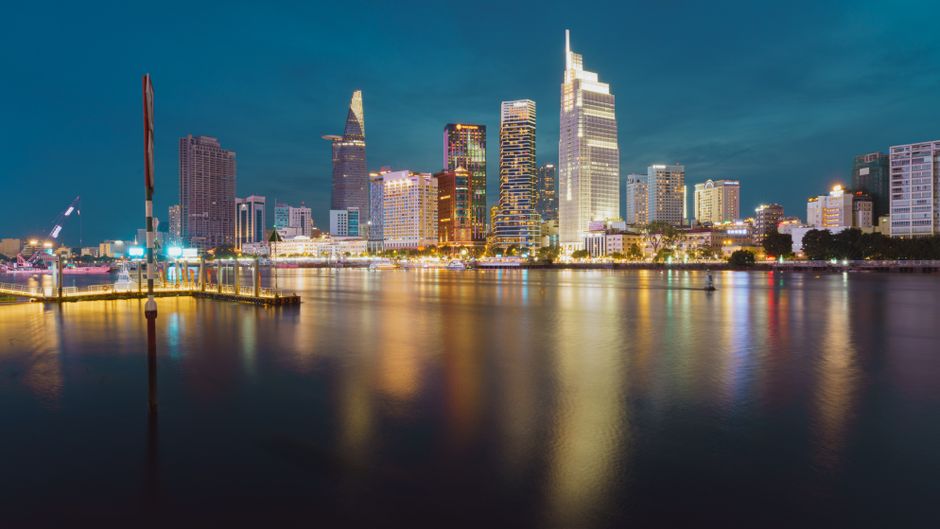 Stunning view of Ho Chi Minh City's skyline with vibrant lights reflecting on the Saigon River at night