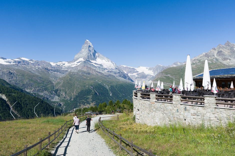 Tourists enjoy a sunny day at a mountain café with a breathtaking view of the Matterhorn in Switzerland