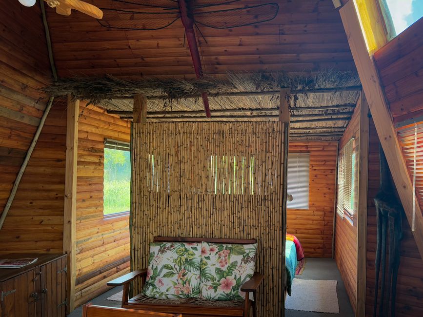 Warm wooden cabin interior featuring rustic bamboo decor and floral accents.