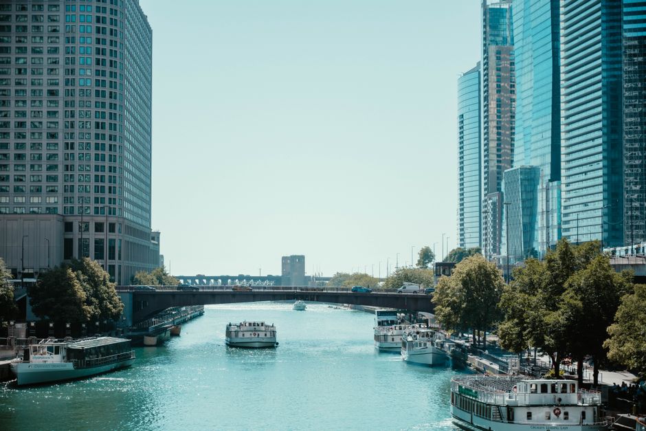 View of the Chicago River surrounded by skyscrapers and boats on a sunny day