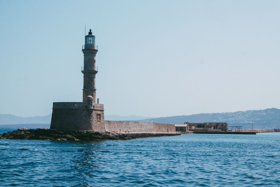 View of the iconic Chania Lighthouse and Venetian Harbor in Crete, Greece on a sunny day